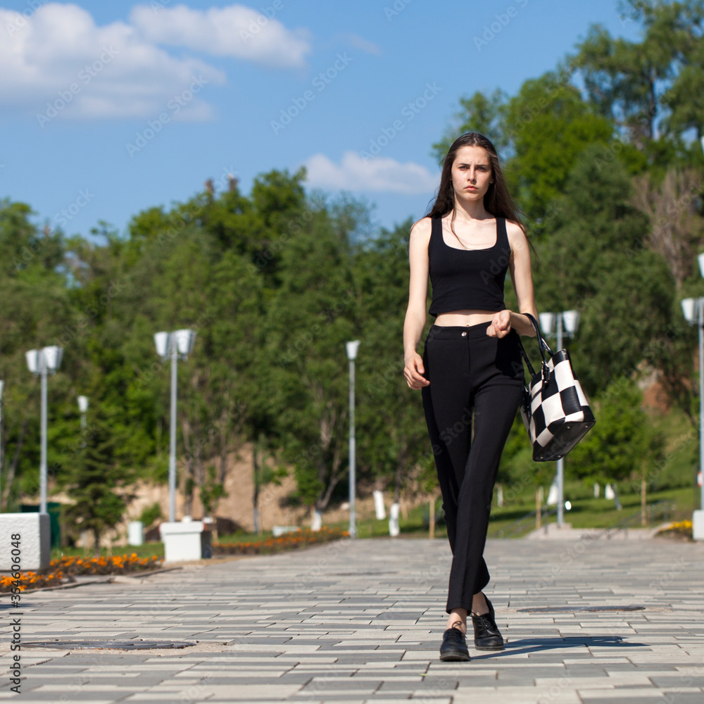 Young woman walking in summer park