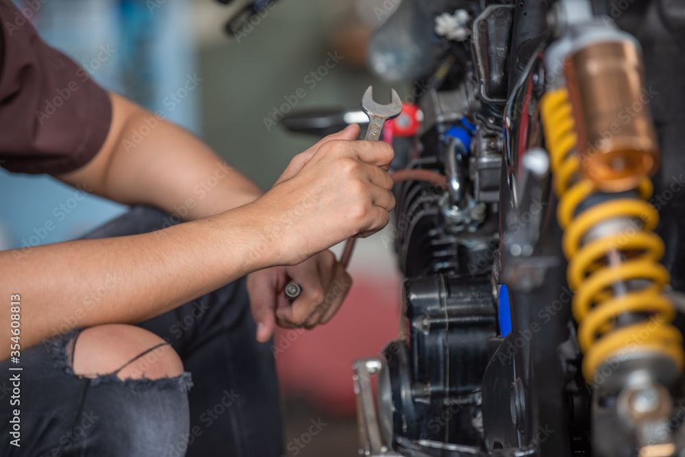 Fototapeta premium Mechanic fixing motorcycle in garage,select focus.