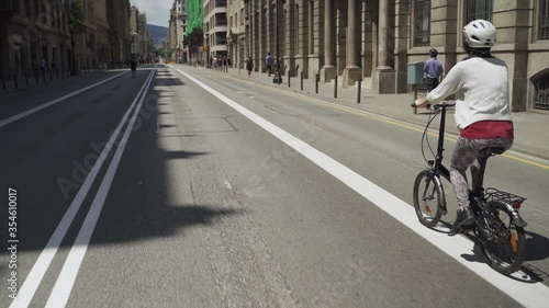 Person riding bicycle in the empty Streets of European City due to Coronavirus Lockdown. Famous Via Laietana thoroughfare in Barcelona City Centre almost empty because Covid-19 crisis  photo