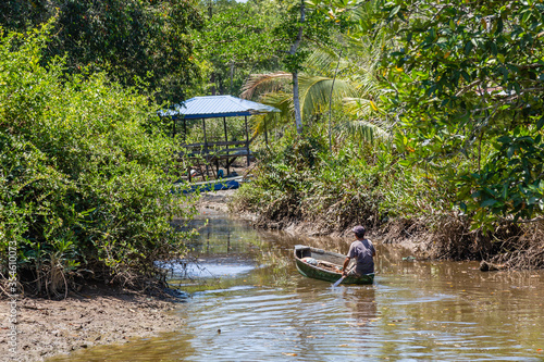 fisherman rowing with his boat at the river at Kampung Saradan photo