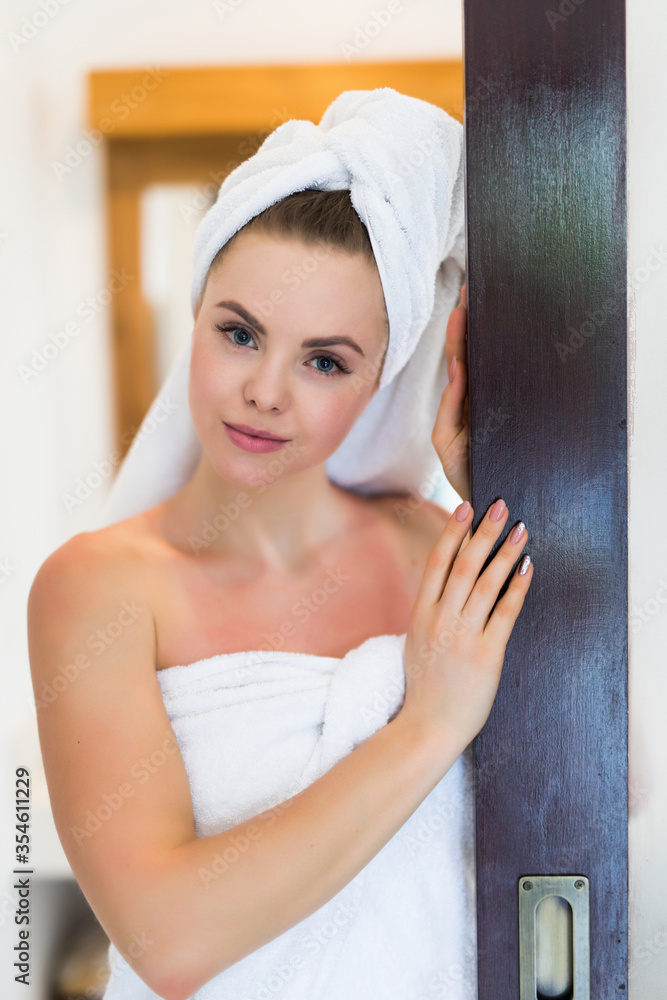 Portrait of woman with bathrobe and towel on head standing indoors in bathroom Portrait of woman with bathrobe and towel on head standing indoors in bathroom