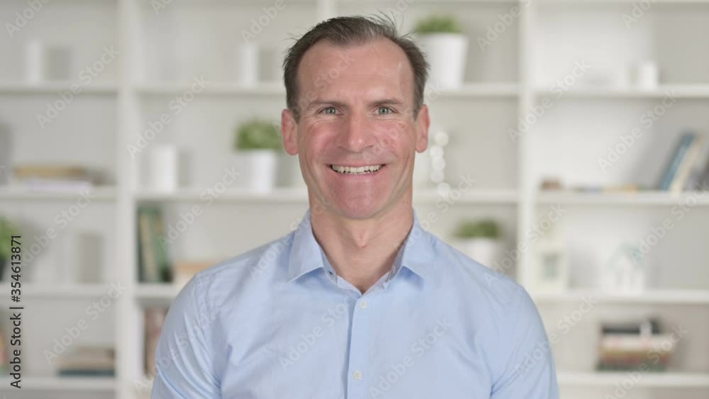 Portrait of Cheerful Middle Aged Businessman Smiling at Camera Portrait of Cheerful Middle Aged Businessman Smiling at Camera