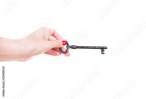 Female hand holds an old key. Isolated on a white background.