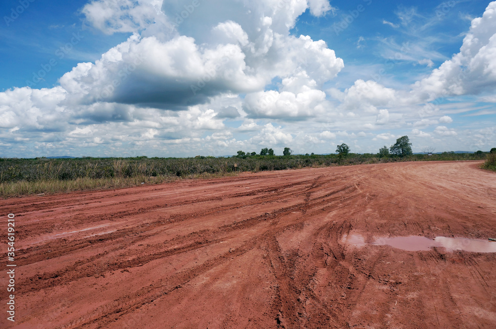 Pools of rainwater on a dirt road in the east kalimantan/indonesia countryside. Country road after the rain.                          