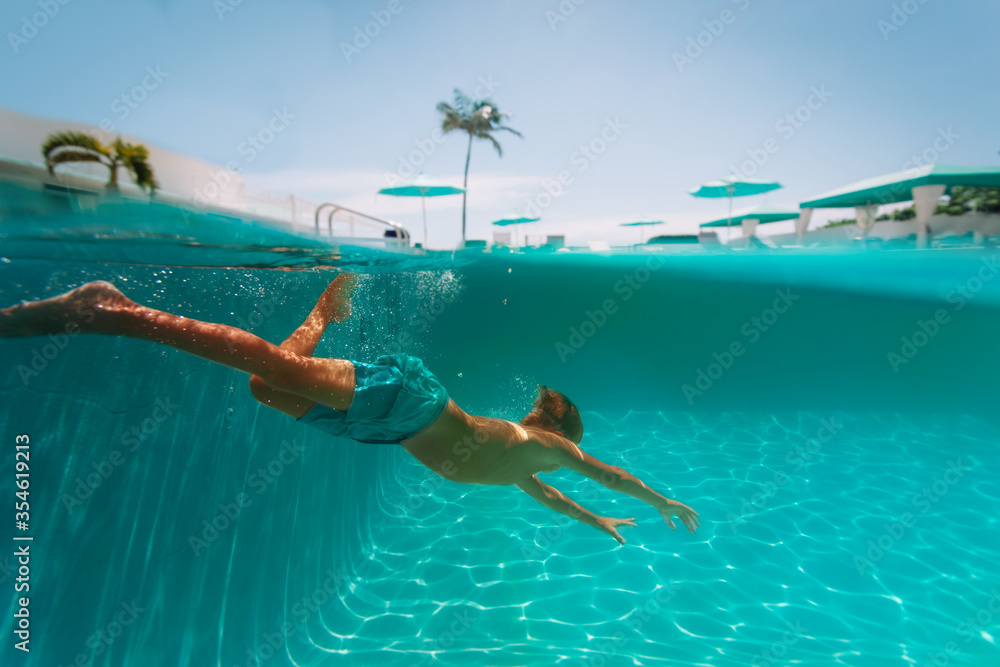 kid diving underwater on tropical beach resort