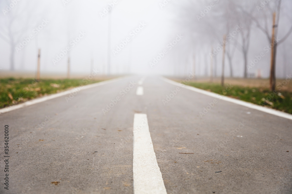 Bike path in the foggy winter day