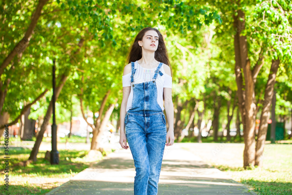Portrait of a young beautiful teenager girl in blue jeans overalls Portrait of a young beautiful teenager girl in blue jeans overalls