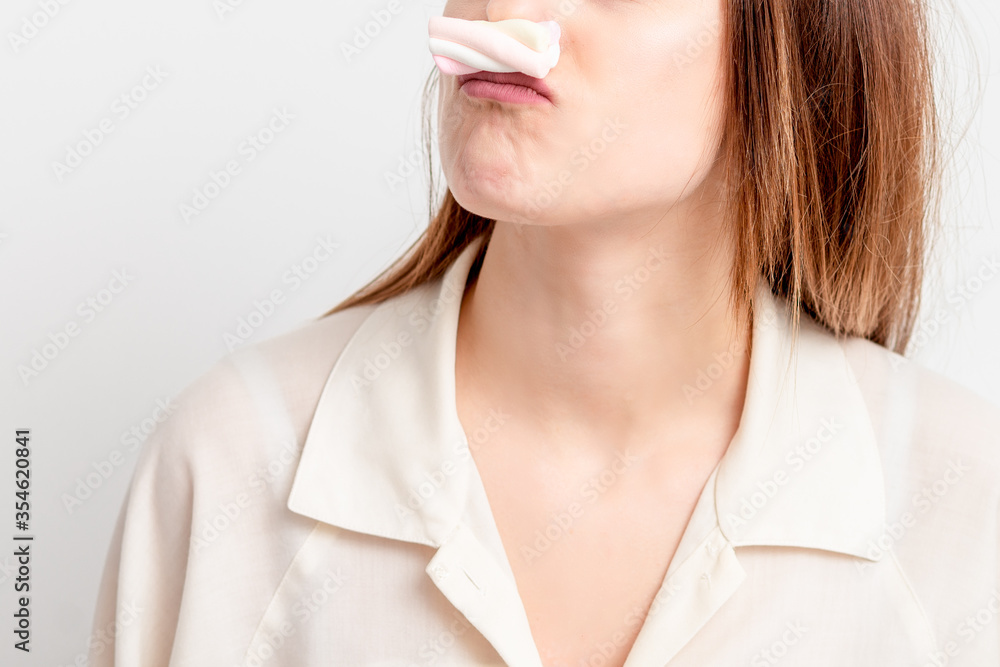 Young woman making mustache with sweet candy marshmallow on white background. Depilation and epilation concept. Young woman making mustache with sweet candy marshmallow on white background. Depilation and epilation concept.