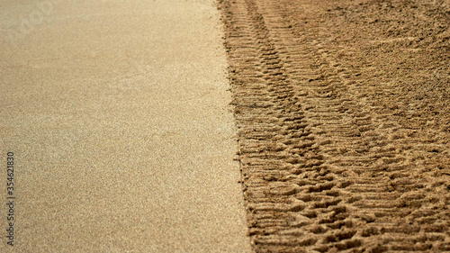 Tire prints on beach sand left by off road vehicle. Abstract background and pattern. photo