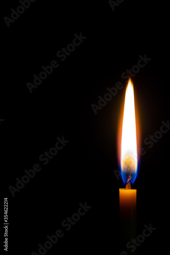 church wax candle burns on a black background