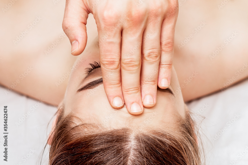 Naklejka premium Top view woman receiving forehead massage by fingers of massage therapist.
