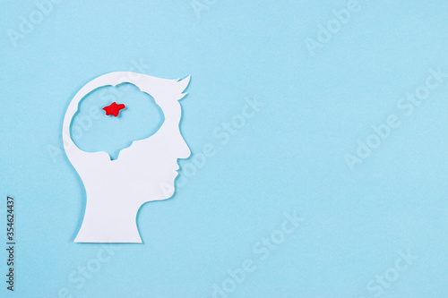 World Brain Tumor Day. Top view of cut paper brain with red tumor on light blue background. Copy space for advertisers.