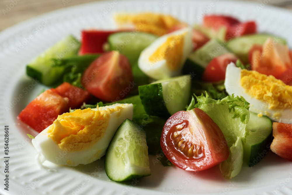 rustic summer salad with fresh cucumbers, tomatoes and eggs on a white plate rustic summer salad with fresh cucumbers, tomatoes and eggs on a white plate