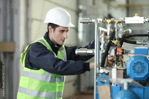 Portrait of a man , factory engineer in work clothes controlling the work process at the airplane manufacturer.	