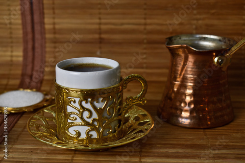 gold cups and Turk for coffee on a light background