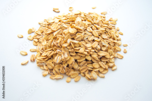 A small pile of dry oatmeal on a white background.