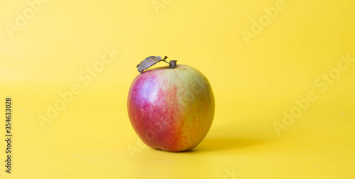 Fresh red yellow apple fruct isolated on yellow background. photo