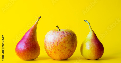 Red yellow fresh pears and apple. Fructs isolated on yellow background.