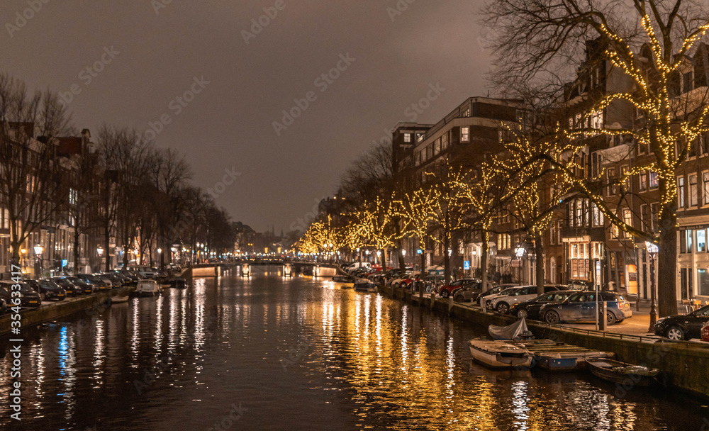 Amsterdam, traditional buildings and river at night