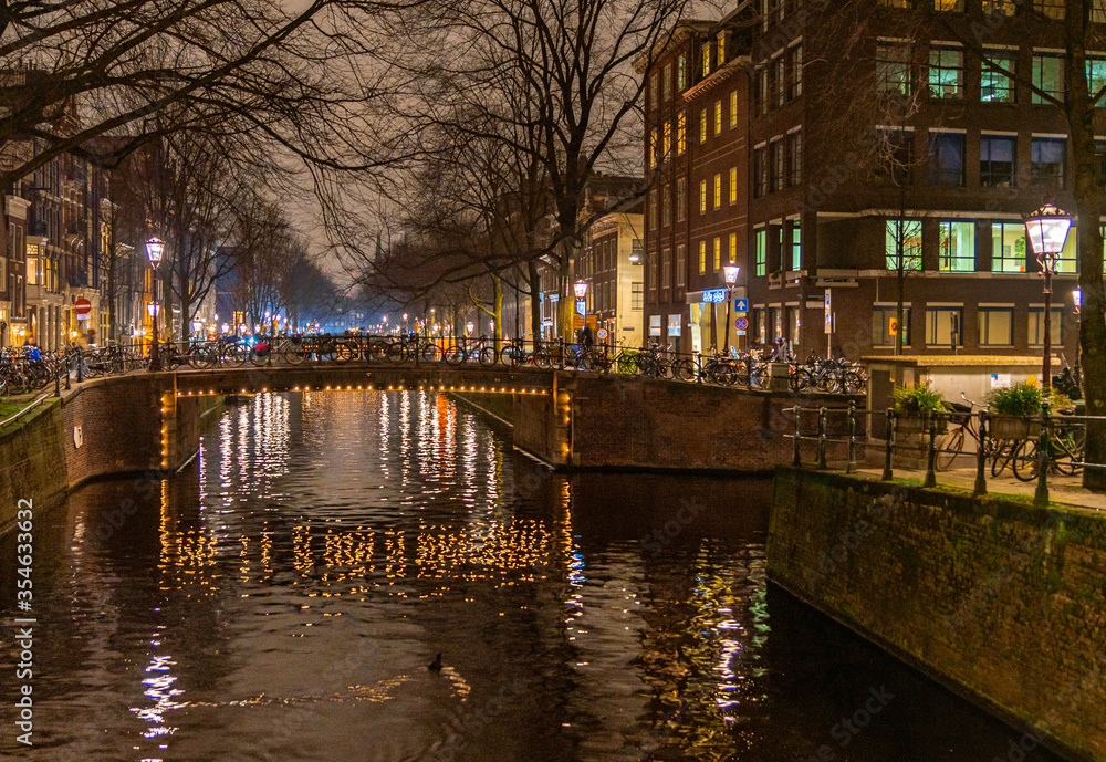 Amsterdam, traditional buildings and river at night