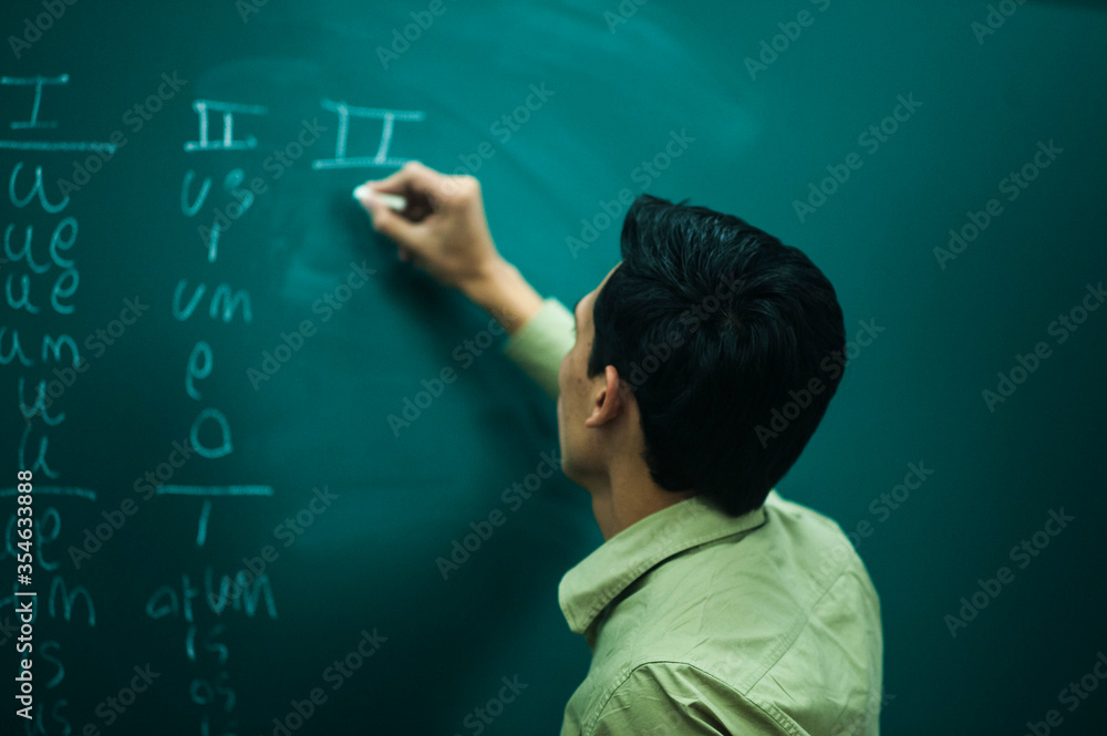 young man writing on a blackboard young man writing on a blackboard