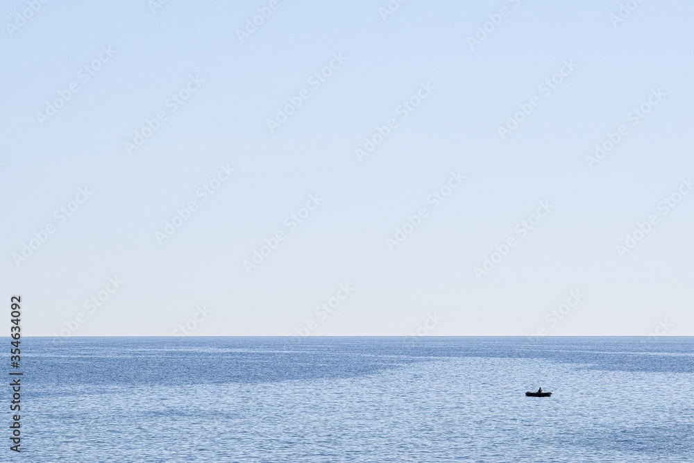 a boat in the sea - very small relative to the big blue ocean