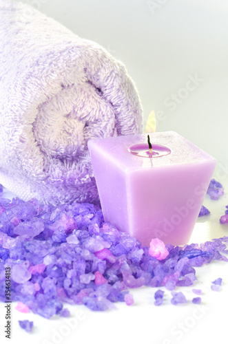 Vertical composition of spa treatment  Candles and Towel with purple sea salt