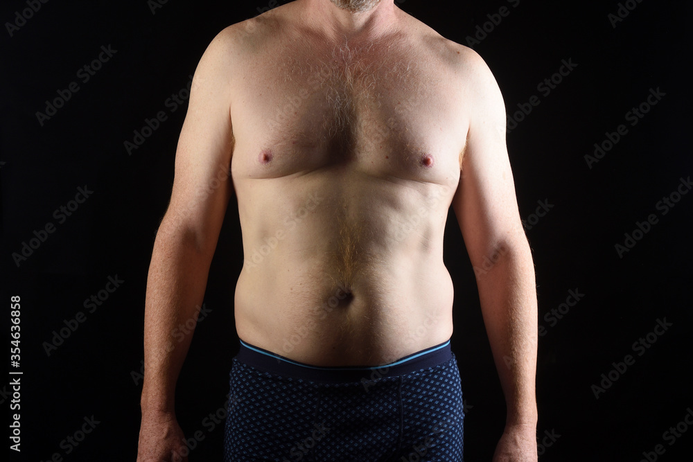 Fototapeta premium body of a real man man on black background, front view