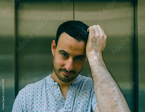 Retrato de hombre peinándose el pelo con la mano
