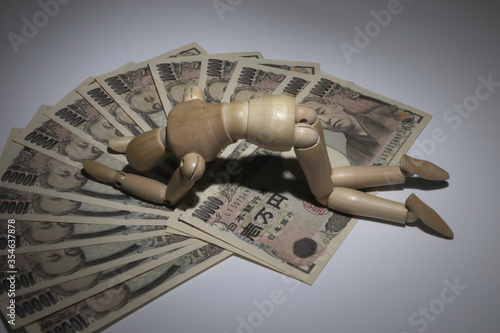 お金と落ち込むデッサン人形