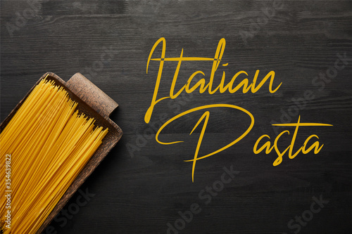top view of raw spaghetti on black wooden background, italian pasta illustration