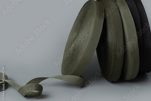 rolls of textile tape on gray background. color tape production.