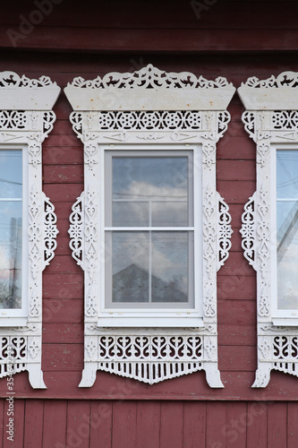 Richly decorated ornamental carved window, frame on vintage wooden rural house in Myt village, Ivanovo region, Russia. Russian traditional national folk style in wooden architecture. Countryside photo