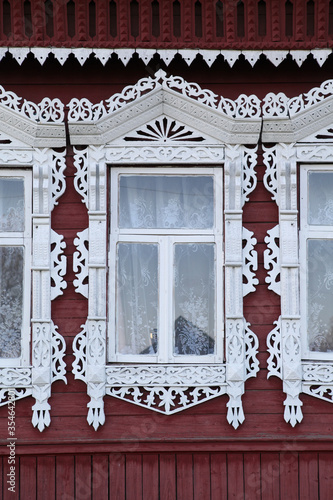 Richly decorated ornamental carved windows, frames on vintage wooden rural house in Myt village, Ivanovo region, Russia. Russian traditional national folk style in wooden architecture. Countryside photo