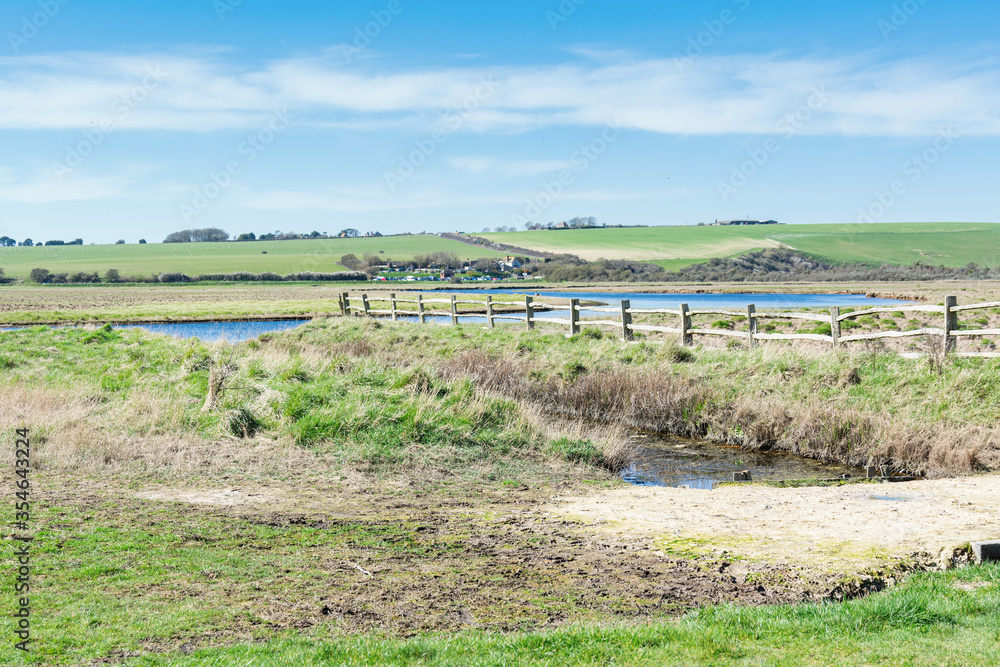 Views of Cucmere river near Seaford and Eastbourne, East Sussex, footpath leading to Cuckmere Haven beach, selective focus