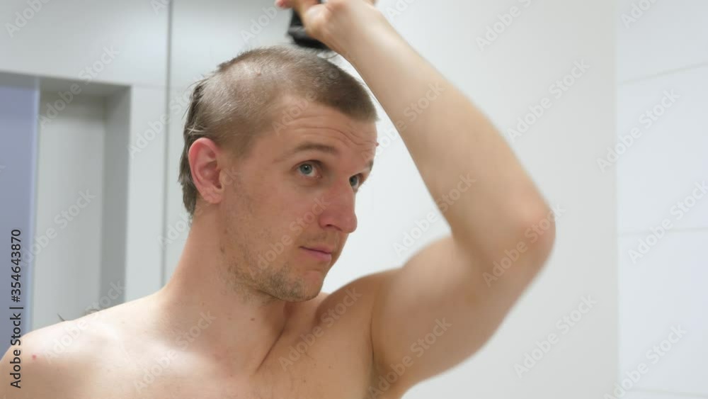 Young Man Cutting His Own Hair During Coronavirus Outbreak. Quarantine Haircut. Young Man Cutting His Own Hair During Coronavirus Outbreak. Quarantine Haircut.