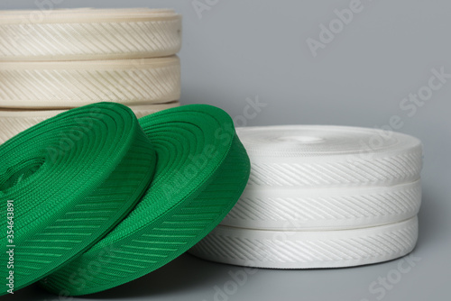 rolls of textile tape on gray background. color tape production.