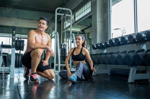Fototapeta Naklejka Na Ścianę i Meble -  Young fitness couple workout together in gym,Sport,Fitness,Training healthy lifestyle.