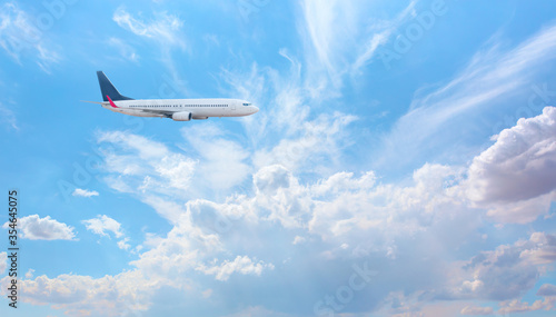 White passenger airplane in the clouds - Travel by air transport © muratart