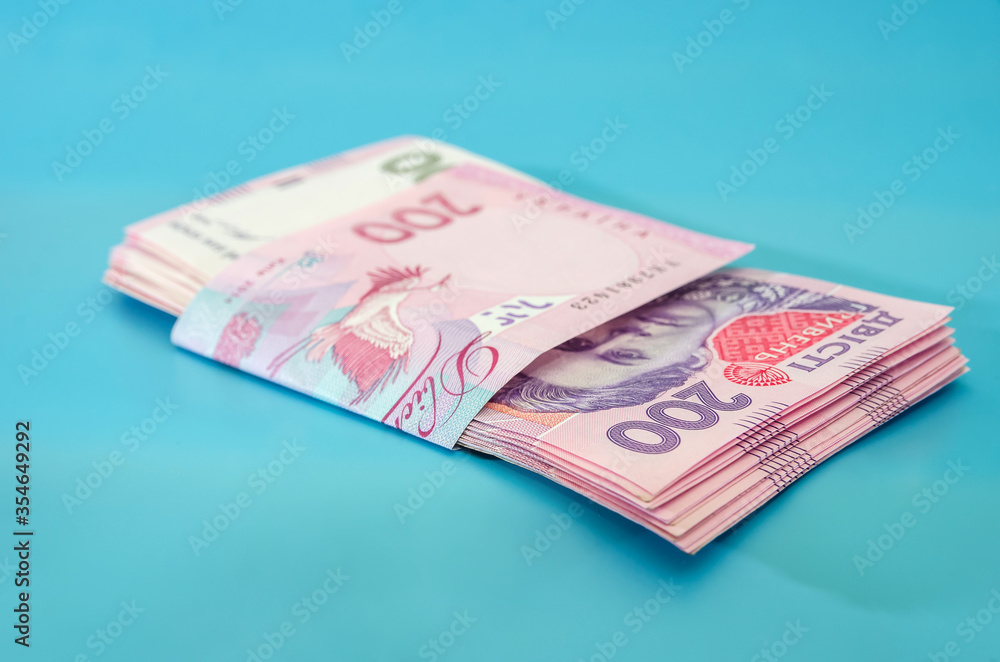 Obraz premium UAH. Money of Ukraine 200 hryvnia, Ukrainian banknotes isolated on blue background