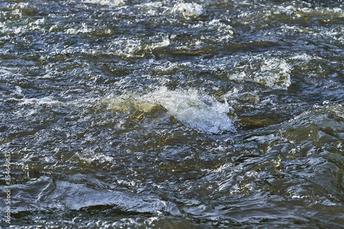 Spray and waves on the surface of the river during a strong wind