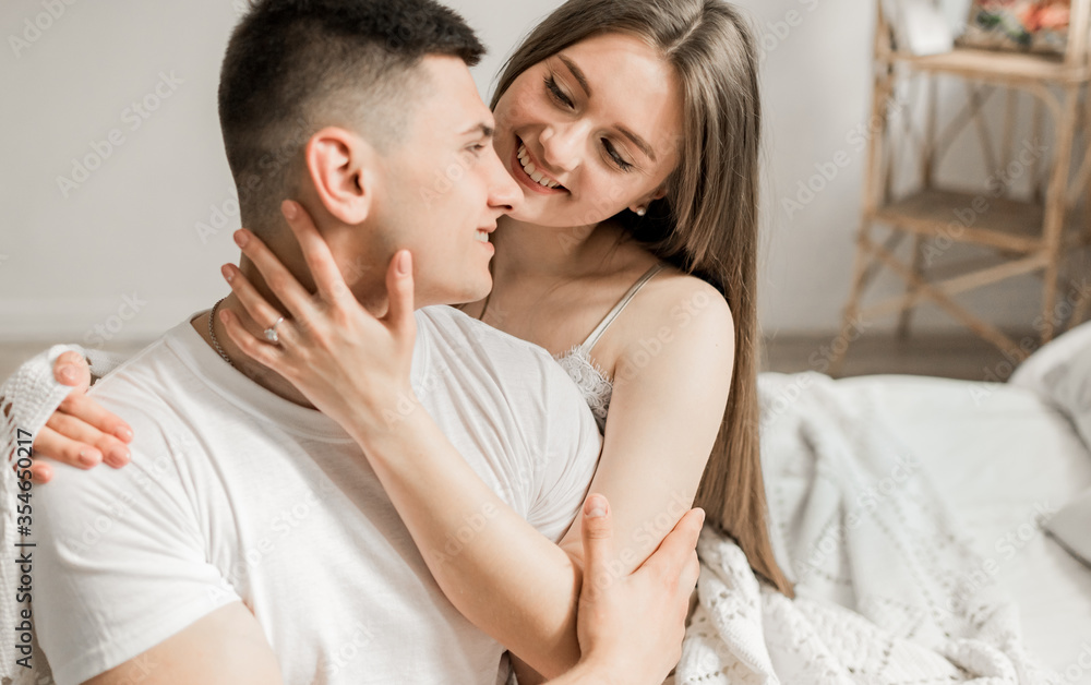 Loving shoot with decor kisses, hugs. Happy couple. Lovers in luxury decoration. Man and woman together. Couple hugging. Newlyweds in interier