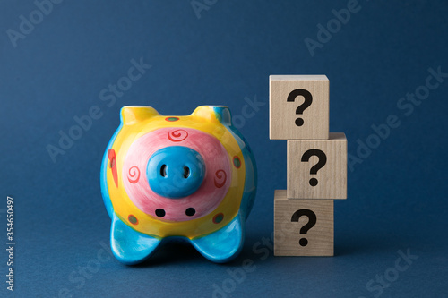 financial crisis concept, piggy bank pig with wooden cubes with questions on them
