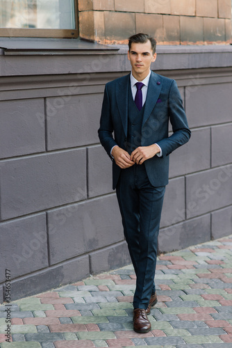 Portrait of an attractive young businessman in urban background wearing suit and a tie.