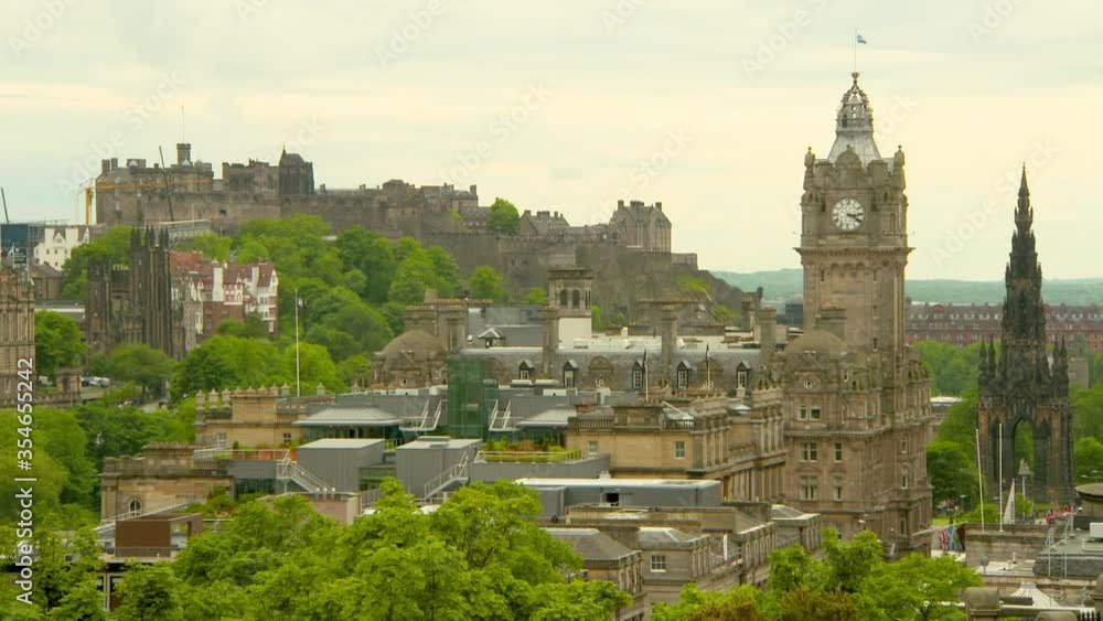 Lockdown shot of hotel by monument with famous historic castle in city against sky - Edinburgh, Scotland Lockdown shot of hotel by monument with famous historic castle in city against sky - Edinburgh, Scotland