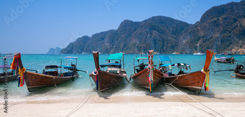 The long tail boat is at the beautiful beach of Phi Phi Island, Krabi, Thailand.