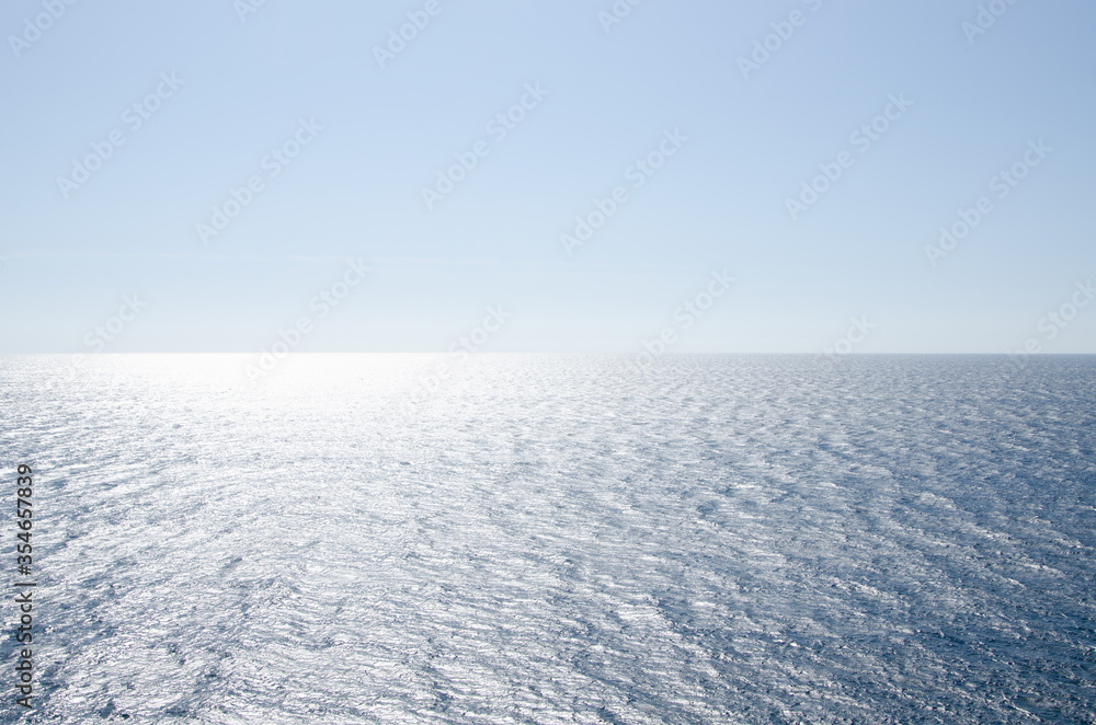 Seascape background of clear sky and vivid blue sea with sunlight reflection on surface Seascape background of clear sky and vivid blue sea with sunlight reflection on surface