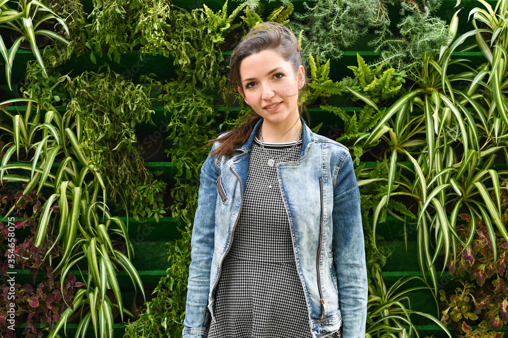 Portrait of a young girl on a background of green plants Portrait of a young girl on a background of green plants