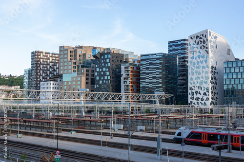 View at Oslo downtown buildings and a train at central railway station. Summer day and a blue sky.