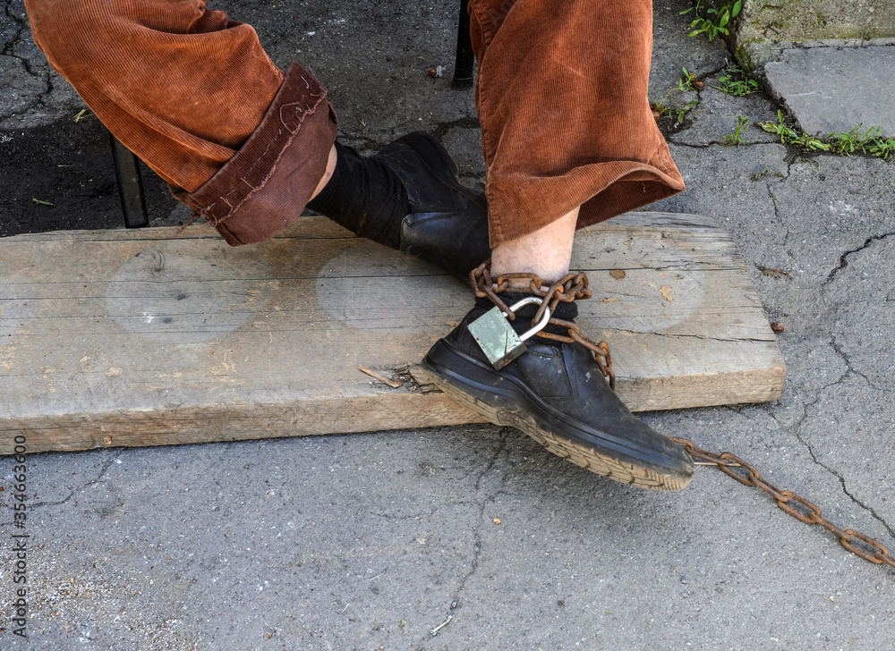 A man in chains, hands and feet. A man in chains, hands and feet.